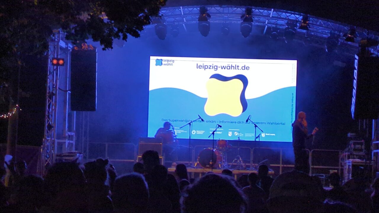 Ein große Anzeige für Leipzig-wählt.de auf der Bühne.